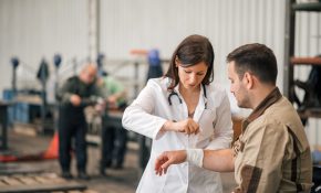 Une médecin soigne le poignet d'un homme qui vient de subir un accident dans le cadre de son travail