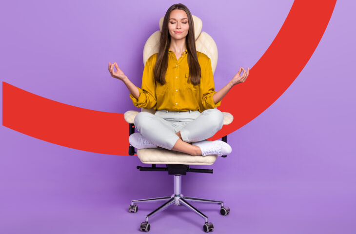 Une jeune femme est assise en tailleur et en position de yoga sur un fauteuil de bureau. Elle a les yeux fermés, le sourire aux lèvres et semble détendue.